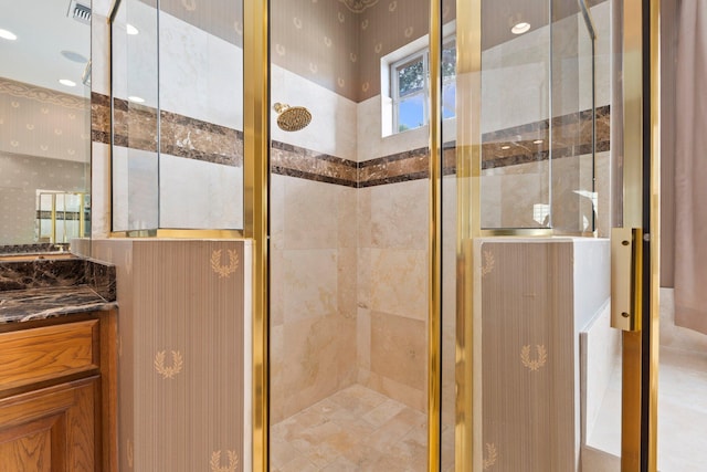 full bath with vanity, a shower stall, visible vents, and wallpapered walls