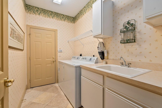 clothes washing area featuring light tile patterned flooring, wallpapered walls, a sink, cabinet space, and independent washer and dryer
