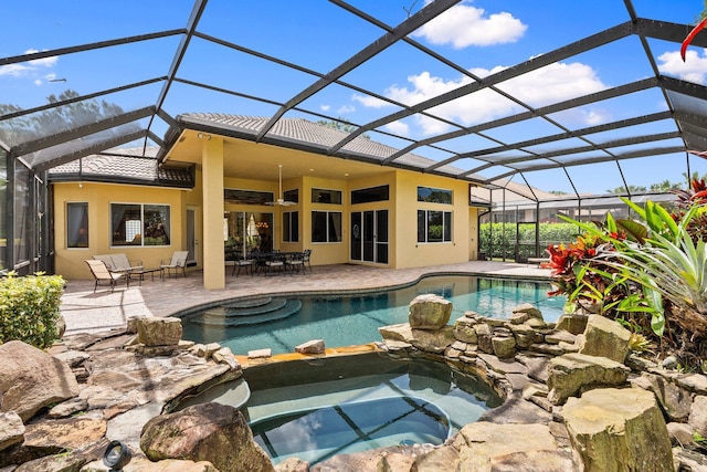 view of swimming pool featuring a lanai, a patio area, and a pool with connected hot tub