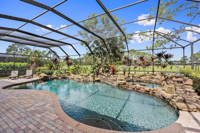 view of swimming pool with a pool with connected hot tub, a lanai, and a patio area