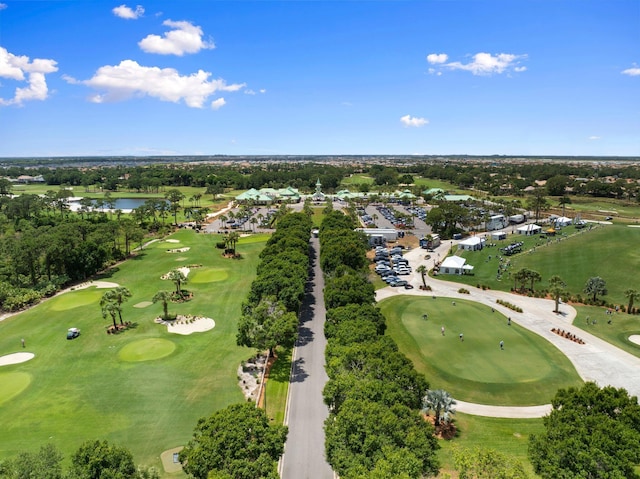 birds eye view of property with view of golf course and a water view
