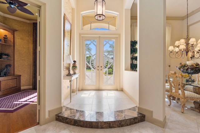 entryway featuring crown molding, tile patterned flooring, arched walkways, french doors, and ceiling fan with notable chandelier