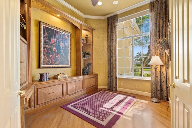 interior space featuring baseboards, ornamental molding, and wood finished floors