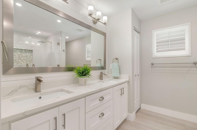 1155 Rainwood Cir, Palm Beach Gardens, FL 33410 - bathroom with double vanity, a sink, a stall shower, and wood finished floors