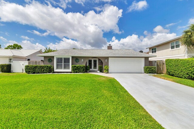 1155 Rainwood Cir, Palm Beach Gardens, FL 33410 - view of front of house with french doors, a front yard, a garage, concrete driveway, and stucco siding