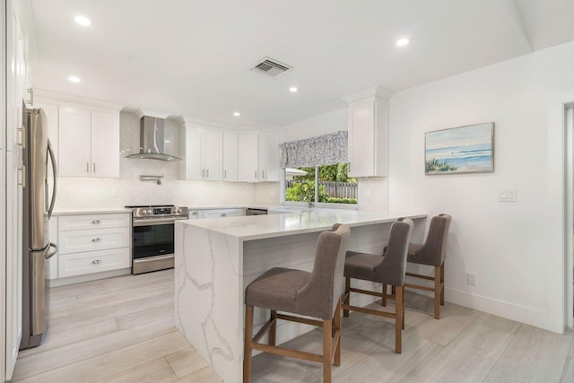 1155 Rainwood Cir, Palm Beach Gardens, FL 33410 - kitchen featuring appliances with stainless steel finishes, wall chimney exhaust hood, a peninsula, backsplash, and visible vents