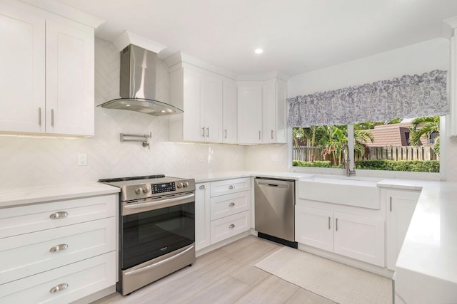 1155 Rainwood Cir, Palm Beach Gardens, FL 33410 - kitchen featuring wall chimney range hood, backsplash, appliances with stainless steel finishes, a sink, and white cabinets