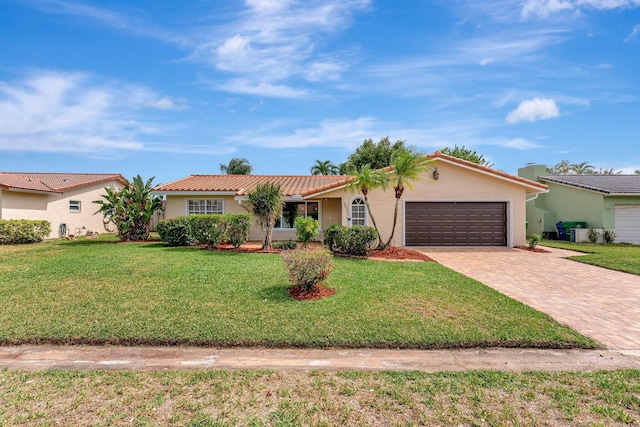 ranch-style house featuring a tile roof, a front yard, a garage, decorative driveway, and stucco siding