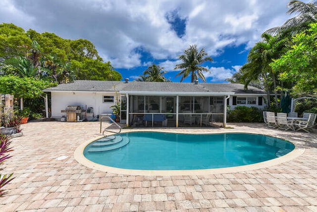 outdoor pool featuring a patio area and a sunroom