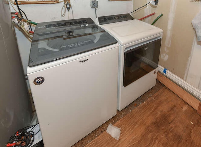 laundry room with separate washer and dryer, wood finished floors, and laundry area
