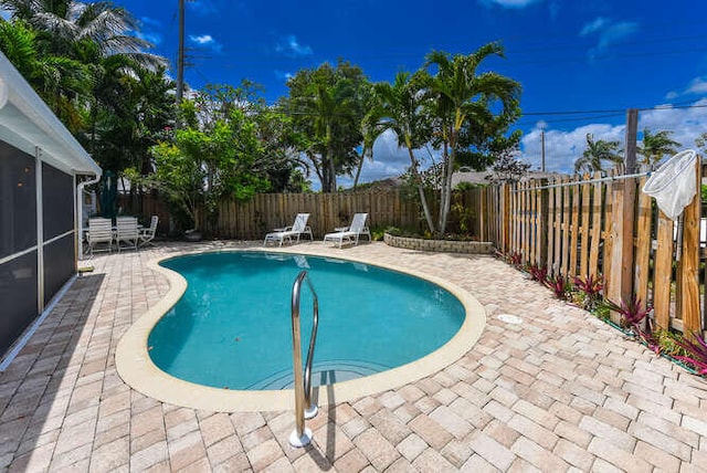view of swimming pool with a patio, a fenced backyard, a fenced in pool, and a sunroom
