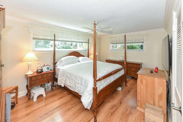 bedroom featuring a textured ceiling, crown molding, ceiling fan, baseboards, and light wood finished floors