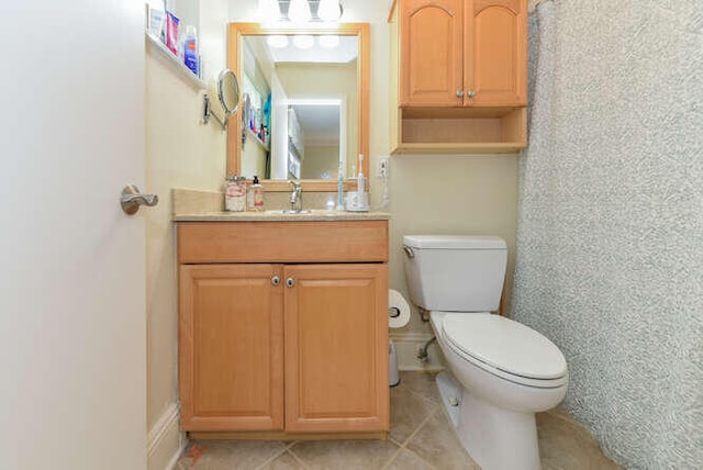 bathroom with toilet, tile patterned flooring, and vanity