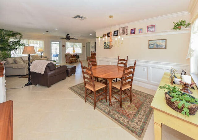 dining area featuring visible vents, ornamental molding, a wainscoted wall, and light tile patterned flooring