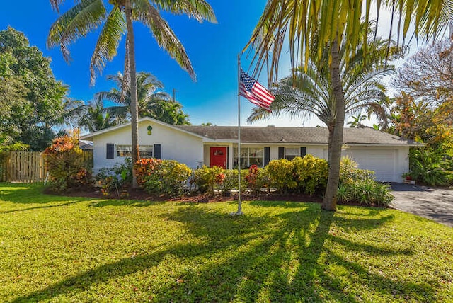 ranch-style home with stucco siding, fence, a garage, driveway, and a front yard