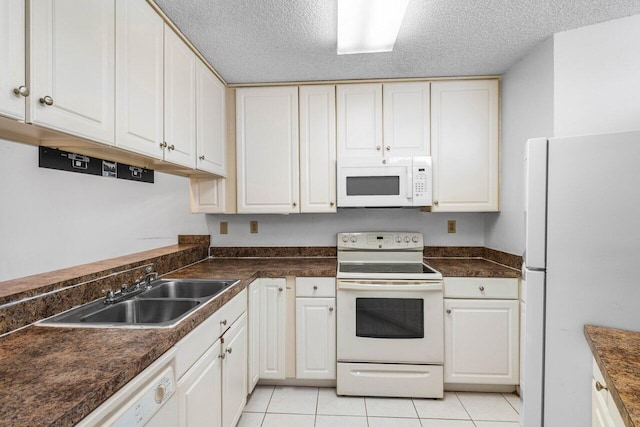 kitchen featuring a sink, dark countertops, and white appliances