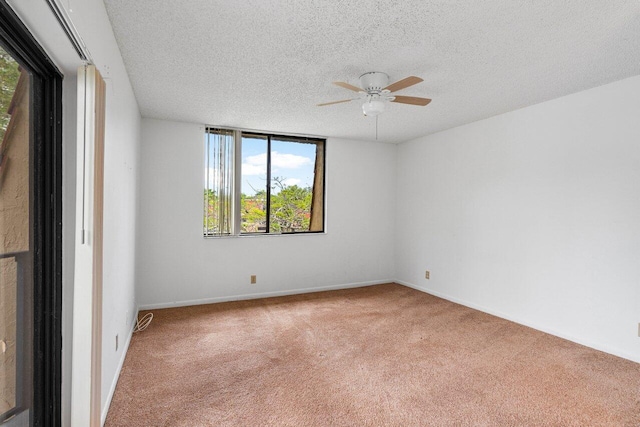 carpeted empty room with plenty of natural light, a ceiling fan, and a textured ceiling