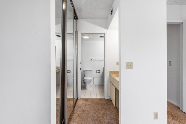 bathroom with vanity, tile patterned floors, toilet, and a textured ceiling