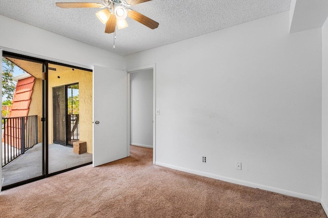 carpeted empty room featuring baseboards, a ceiling fan, and a textured ceiling