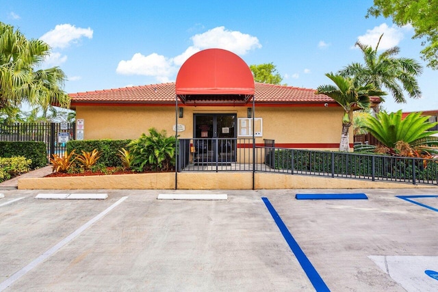 view of building exterior featuring fence and uncovered parking