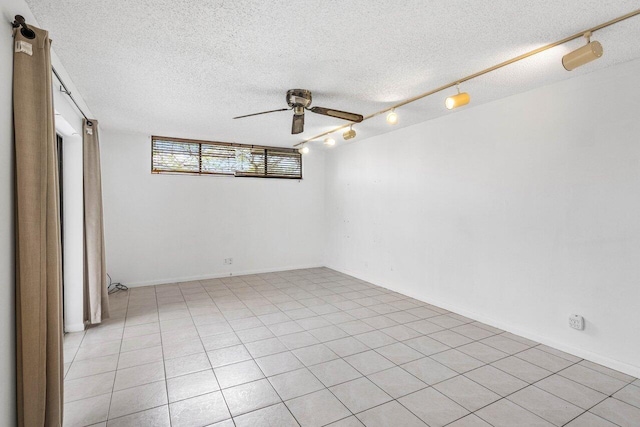 spare room with a textured ceiling, ceiling fan, and rail lighting