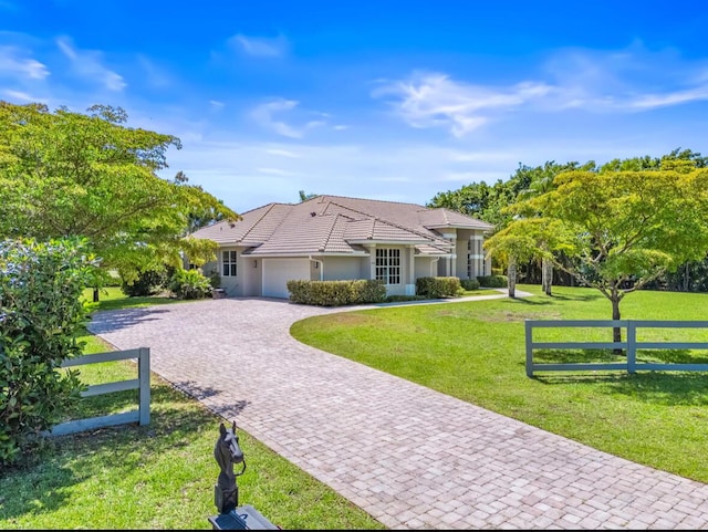 3950 Fieldview Way, Wellington, FL 33414 - ranch-style house featuring a front yard, stucco siding, decorative driveway, an attached garage, and fence