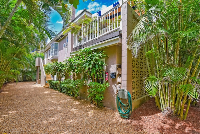 126 Peruvian Ave, Palm Beach, FL 33480 - view of side of home featuring a balcony, stucco siding, and stairway