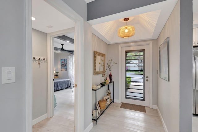 entrance foyer featuring ceiling fan, light wood-style flooring, and baseboards