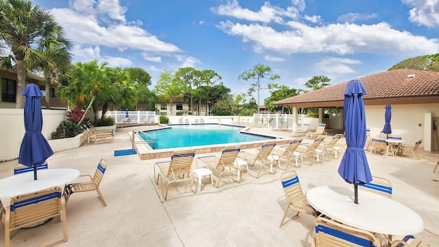 pool featuring fence, a patio, and outdoor dining area