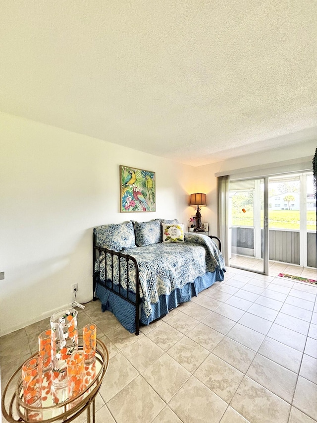 82 Camden Unit D, West Palm Beach, FL 33417 - bedroom with access to exterior, a textured ceiling, and light tile patterned floors