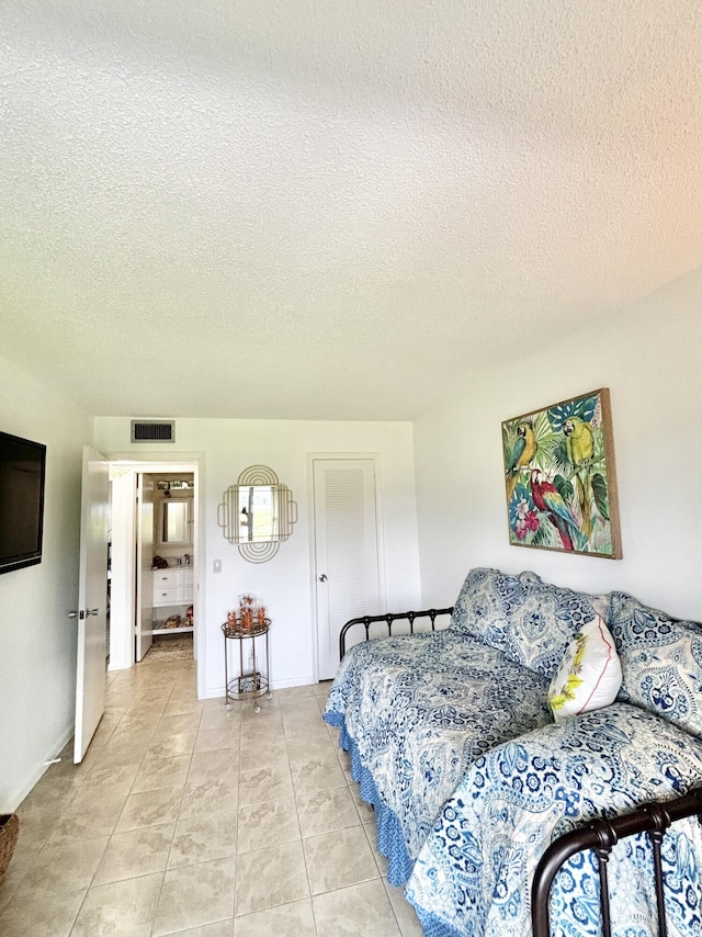 82 Camden Unit D, West Palm Beach, FL 33417 - bedroom with light tile patterned floors and a textured ceiling