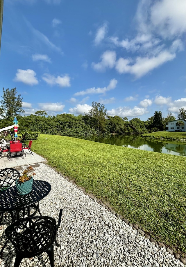 82 Camden Unit D, West Palm Beach, FL 33417 - view of grassy yard with a water view and a patio