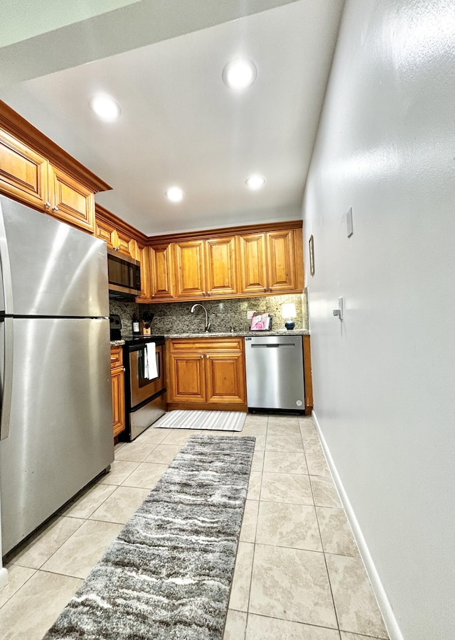82 Camden Unit D, West Palm Beach, FL 33417 - kitchen featuring appliances with stainless steel finishes, backsplash, brown cabinetry, light tile patterned floors, and recessed lighting