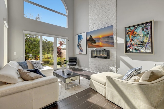 2530 NW 52nd St, Boca Raton, FL 33496 - living area with a high ceiling, wood finished floors, a stone fireplace, and baseboards