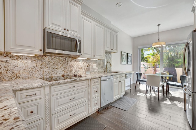 2530 NW 52nd St, Boca Raton, FL 33496 - kitchen featuring stainless steel appliances, a sink, tasteful backsplash, dark wood-style floors, and white cabinetry