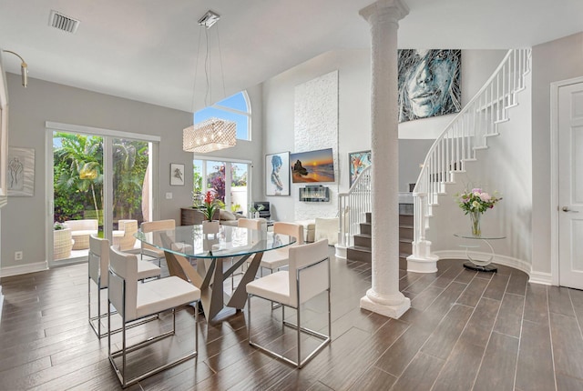 2530 NW 52nd St, Boca Raton, FL 33496 - dining area with stairway, dark wood-style floors, ornate columns, baseboards, and a high ceiling