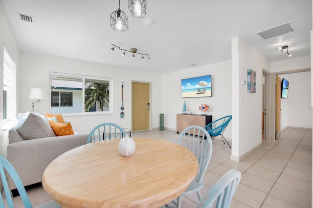 dining space featuring light tile patterned flooring, healthy amount of natural light, and baseboards