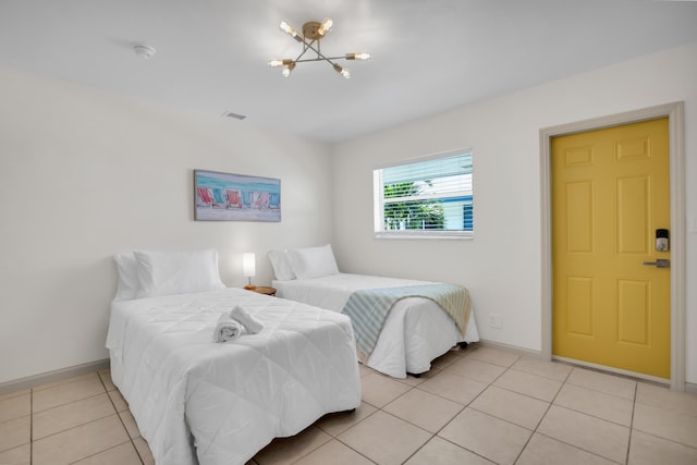 bedroom with a chandelier, baseboards, and light tile patterned floors
