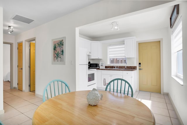 dining area featuring light tile patterned floors, plenty of natural light, and baseboards