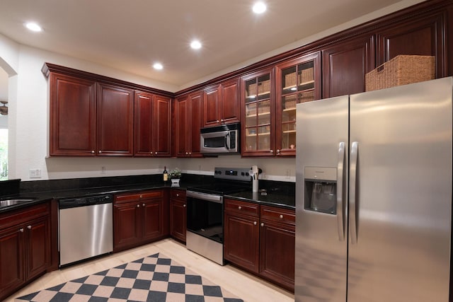 4891 Bonsai Cir Unit 105, Palm Beach Gardens, FL 33418 - kitchen featuring recessed lighting, dark countertops, appliances with stainless steel finishes, and arched walkways
