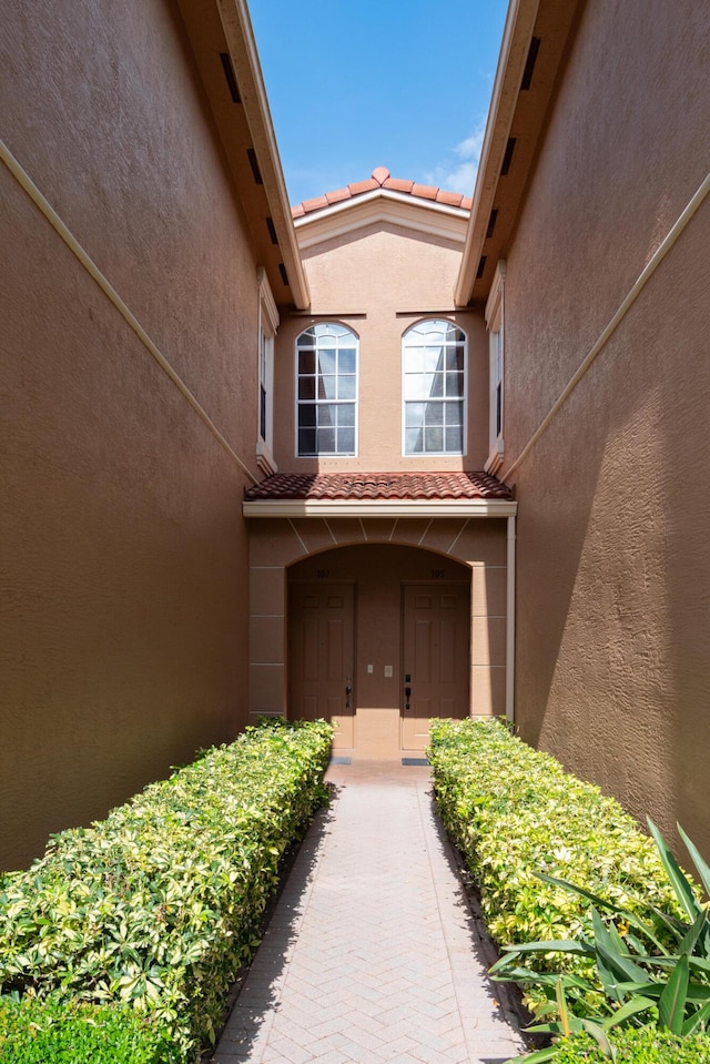 4891 Bonsai Cir Unit 105, Palm Beach Gardens, FL 33418 - doorway to property featuring a tiled roof and stucco siding