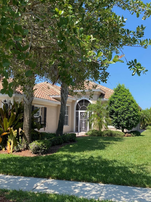 3531 Plume Way SE, Palm Bay, FL 32909 - view of front facade with stucco siding, a tile roof, and a front yard