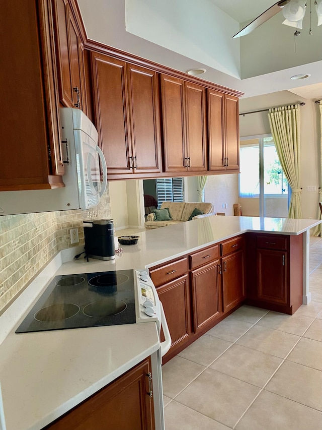3531 Plume Way SE, Palm Bay, FL 32909 - kitchen with a peninsula, ceiling fan, light countertops, electric range oven, and light tile patterned floors