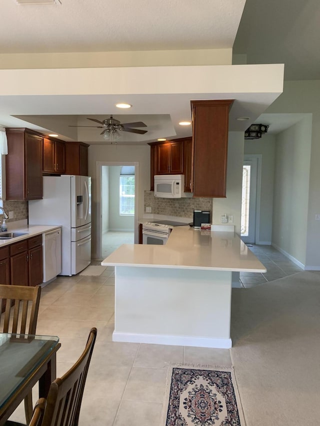 3531 Plume Way SE, Palm Bay, FL 32909 - kitchen featuring backsplash, light countertops, a sink, a peninsula, and white appliances