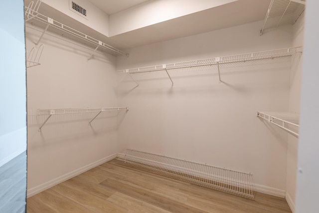 spacious closet featuring visible vents and wood finished floors