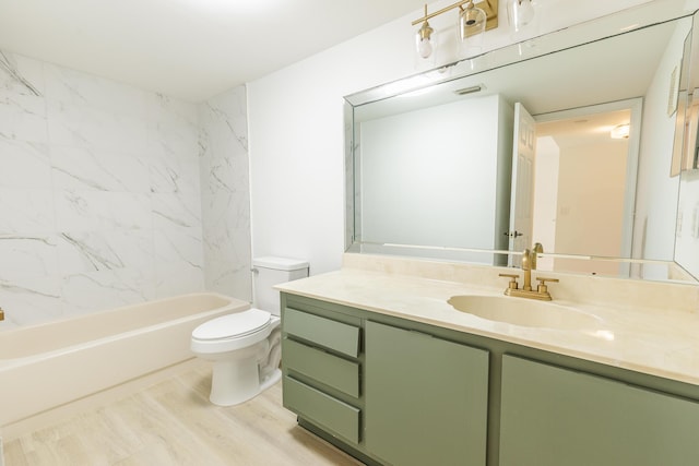 bathroom featuring visible vents, toilet, wood finished floors, vanity, and bathtub / shower combination