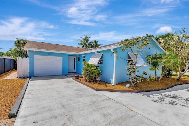 387 Yvonne Dr, West Palm Beach, FL 33406 - ranch-style house featuring concrete driveway, a garage, stucco siding, and fence