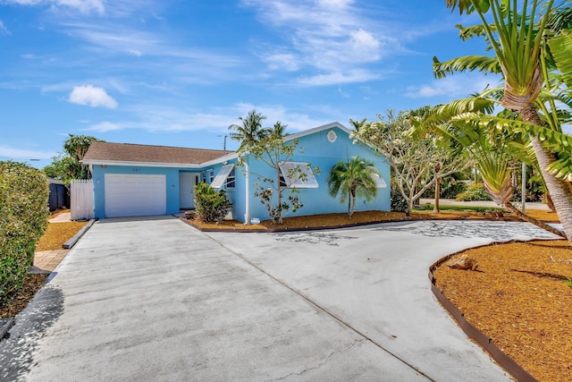 387 Yvonne Dr, West Palm Beach, FL 33406 - view of front of home featuring driveway, a garage, and stucco siding