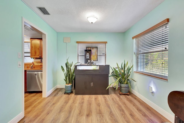 387 Yvonne Dr, West Palm Beach, FL 33406 - dining room with wood finished floors, plenty of natural light, baseboards, and a textured ceiling