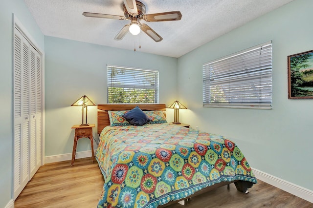 387 Yvonne Dr, West Palm Beach, FL 33406 - bedroom with a closet, wood finished floors, baseboards, a textured ceiling, and ceiling fan